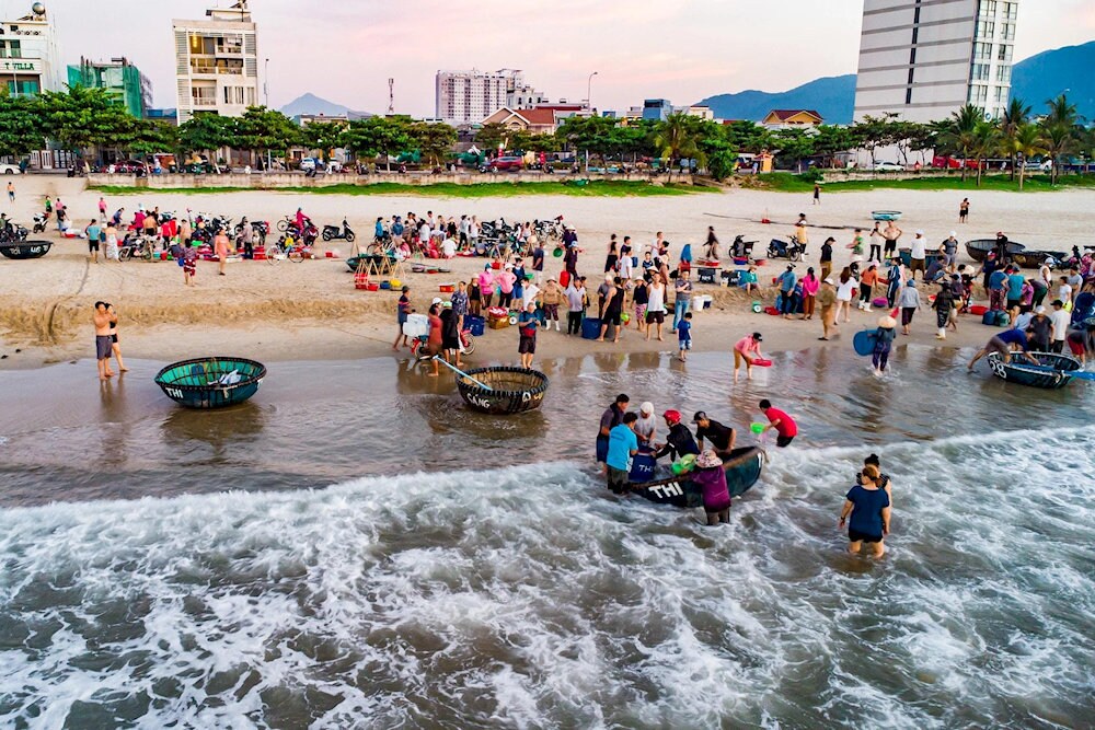 Người dân và du khách tấp nập mua bán hải sản tại biển Mân Thái lúc sớm bình minh
